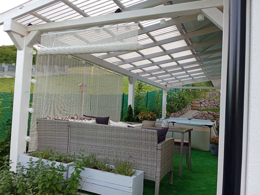 Biela pergola u domu zastrešená polykarbonátom
