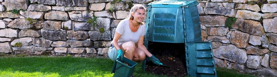 Žena naberajúce hnojivo zo záhradného kompostéra