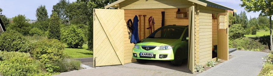 Drevená garáž Karibu sa zaparkovaným vozidlom zelenej farby